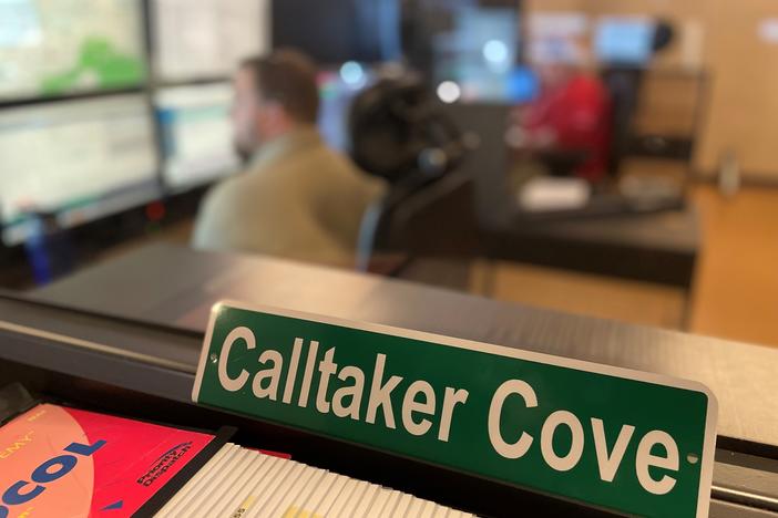 a sign reads "calltaker cove" inside the Cobb County 911 call center.