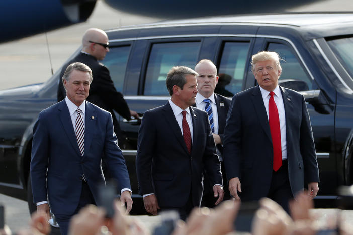 Georgia Republican gubernatorial candidate Brian Kemp, center, walks with President Donald Trump, right, and Sen. David Perdue (R-Ga) as Trump arrives for a rally Sunday, Nov. 4, 2018, in Macon, Ga.