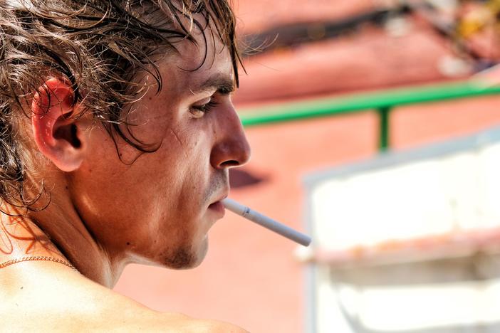 Close up of man's face with an unlit cigarette in his mouth