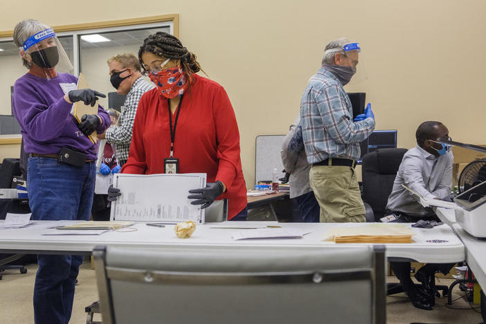 Now former Macon-Bibb County, Ga., Elections Supervisor Jeanetta Watson (third from left) takes questions from poll monitors during a test of the county's electronic ballot scanning system on the first day of the Georgia presidential ballot recount in 2020. 
