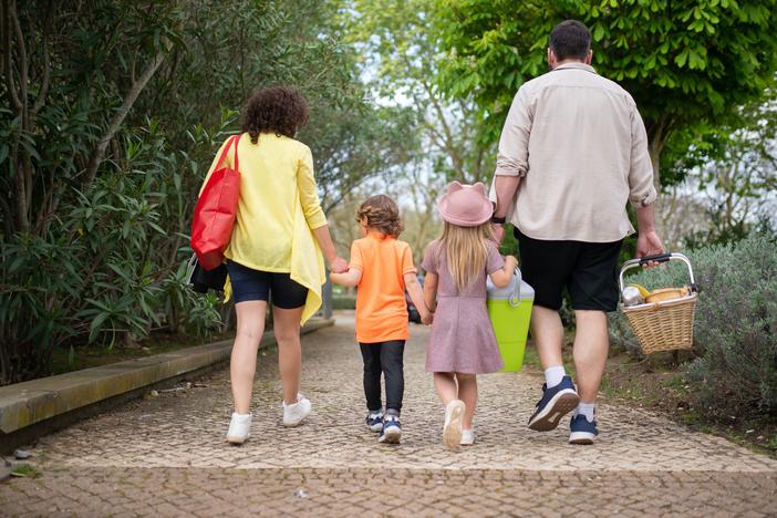 children walk with parents for a picnic