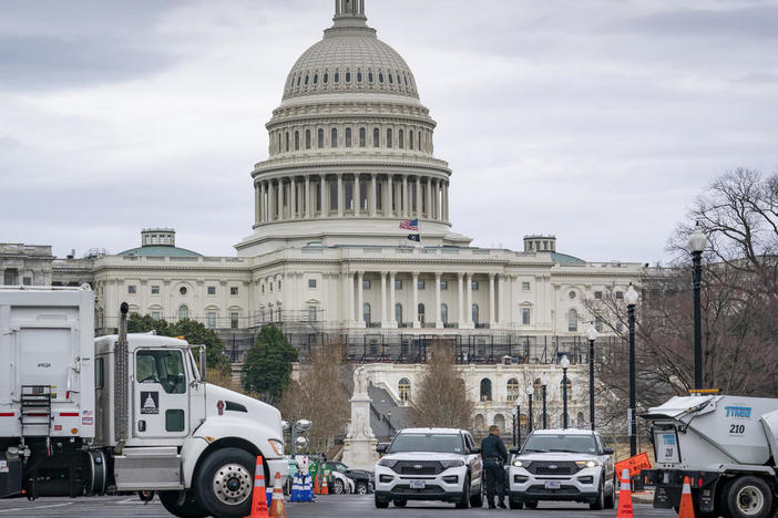 Heavy vehicles, including garbage trucks and snow plows, are set near the entrance to Capitol Hill at Pennsylvania Avenue and 3rd Street NW in Washington on Tuesday.