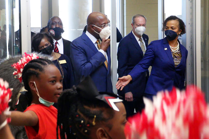 U.S. Sen. Raphael Warnock, second from center, arrives Tuesday morning at Dorothy Height Elementary School in Columbus, Georgia.