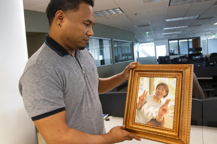 Robert Peterson holds a photo of his late mother, Yong Ae Yue, on Thursday, March 10, 2022, in Atlanta. Yue was one of eight people shot and killed at various massage businesses on March 16, 2021, in the Atlanta area. Many family members and friends of the victims have been struggling with grief, trying to heal and making sure their loved ones aren't forgotten. 