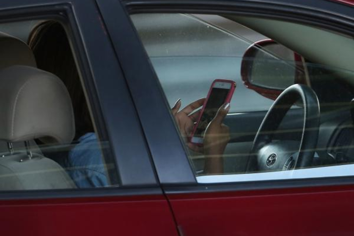 A person uses a cellphone in a car