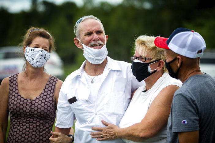 Dennis Perry, center, standing beside wife Brenda Perry gets emotional while thanking the team from the Georgia Innocence Project after they worked to get his release after 20 years behind bars, Thursday, July 23, 2020, in Nicholls, Ga. Perry was granted bond Thursday after his conviction in the 1985 killings of a couple at a south Georgia church was overturned.