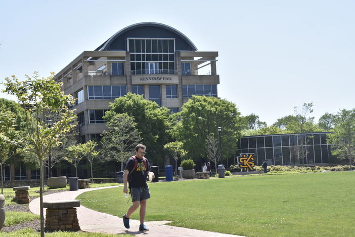 A student walks past the campus green at Kennesaw State University. Lawmakers hope to lower the costs of attending Georgia’s public universities, but the cost of living remains high as inflation rises.