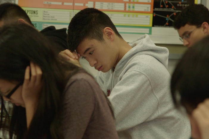 Students in a classroom taking a test.