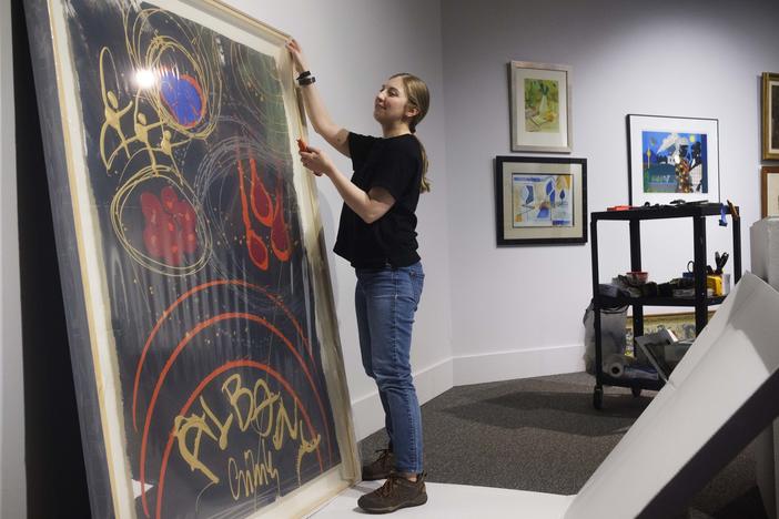 Albany Museum of Art Katie Dillard unpacks a repaired painting by glass artist Dale Chihuly while mounting the show titled "Homecoming" recently. 