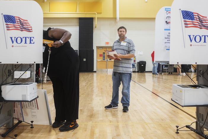 Republican poll watcher Brad Emerton examined each voting machine, making sure vote counts were at zero, as officials set up the East Macon 3 voting precinct Tuesday morning.