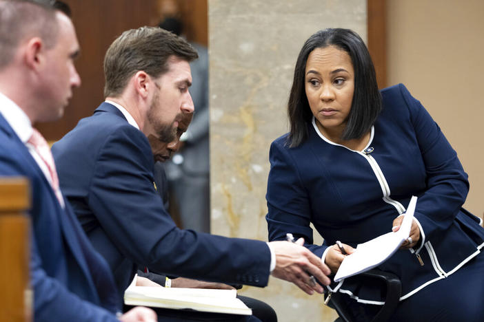 Fulton County District Attorney Fani Willis, right, talks with a member of her team during proceedings to seat a special purpose grand jury in Fulton County, Georgia, on Monday, May 2, 2022, to look into the actions of former President Donald Trump and his supporters who tried to overturn the results of the 2020 election. The hearing took place in Atlanta.