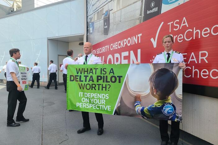 Delta Air Lines pilots march outside Hartsfield-Jackson Atlanta International Airport's South Terminal on June 30, 2022, as part of a nationwide demand for better pay, scheduling and retirement benefits