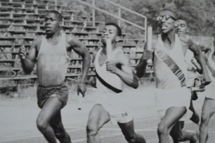 Young men racing in a black and white photo.