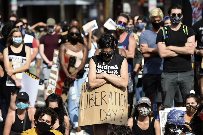 An attendee takes part in a moment of silence at a Juneteenth forum, Friday, June 19, 2020, outside the Laugh Factory comedy club in Los Angeles. Juneteenth marks the day in 1865 when federal troops arrived in Galveston, Texas, to take control of the state and ensure all enslaved people be freed, more than two years after the Emancipation Proclamation.