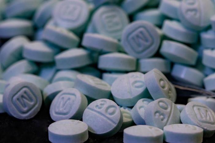 File photo of several dozen pills containing fentanyl. They are circular and blue, with one side showing a capital letter M and the other side showing the number 30.