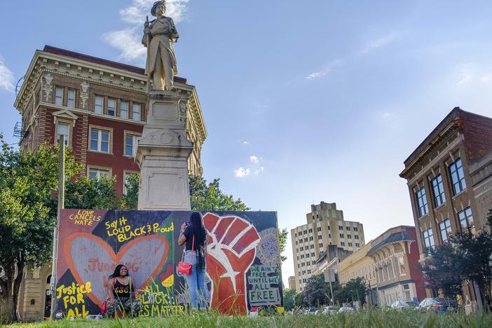 Posing for pictures by the Black Lives Matter themed art around the base of a Confederate monument on Cotton Avenue in Macon in the summer of 2020. The statue is one of two soon to be moved from downtown Macon. 