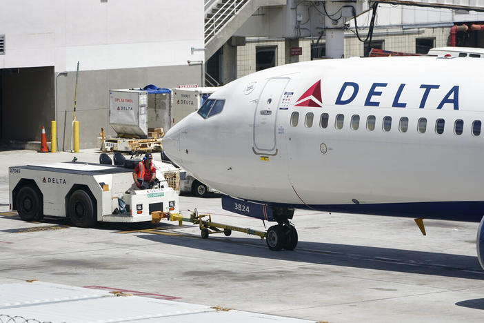 A tug driver pushes a Delta Air Lines Boeing 737 back from a gate, Thursday, July 7, 2022, at the Fort Lauderdale-Hollywood International Airport in Fort Lauderdale, Fla. Delta Air Lines said Wednesday, July 13, 2022, that it earned $735 million in the second quarter. Earnings per share fell short of Wall Street expectations, however, which the airline blamed on high fuel prices and more than 4,000 canceled flights in May and June.