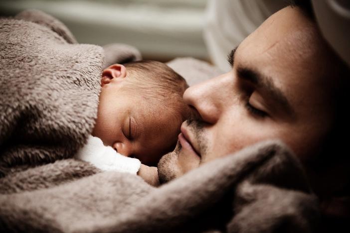 portrait of father holding a newborn baby