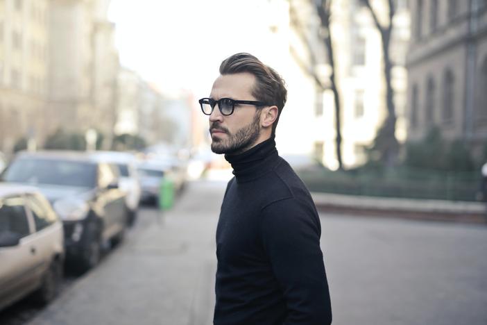 A man in glasses standing on a street