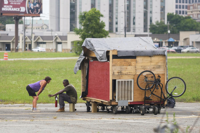 Pat Garrett, left, and her partner Cedric moments before wheeling their home out of the way of Macon-Bibb County Public Works bulldozer on June 8, 2022. Macon-Bibb County bulldozed one of the city's largest homeless encampments, saying it was necessary as a public health measure.