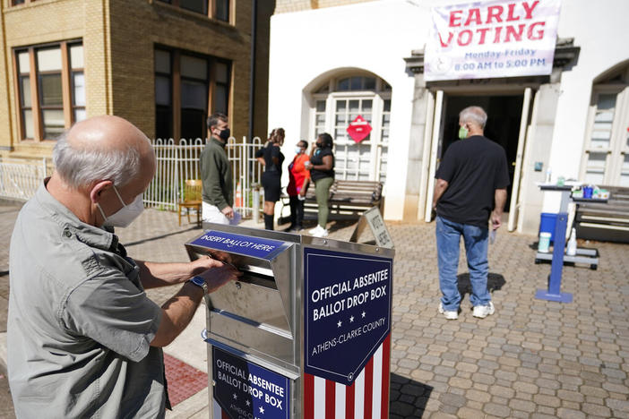 A voter submits a ballot in an official drop box during early voting in Athens, Ga., on Oct. 19, 2020. The widespread use of absentee ballot drop boxes during the 2020 election was largely trouble-free, contrary to claims made by former President Donald Trump and his Republican allies. An Associated Press survey of state election officials across the U.S. revealed no problems that could have affected the results, including from fraud, vandalism or theft.
