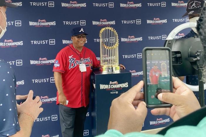 Man posing with Atlanta Braves trophy