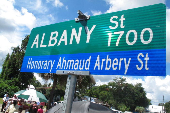 A crowd gathers under a new sign designating a city roadway as Honorary Ahmaud Arbery Street on Tuesday, Aug. 9, 2022, in Brunswick, Ga. City officials approved the honor for Arbery, a 25-year-old Black man who was fatally shot in February 2020 after being chased by three white men in pickup trucks who spotted him running in their neighborhood. All three men were later convicted of murder and federal hate crimes. 