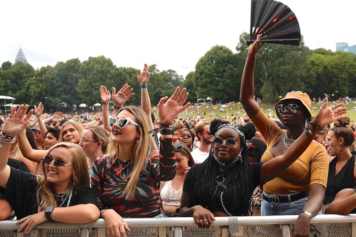 Festival attendees stand against barricades before the artist performs..