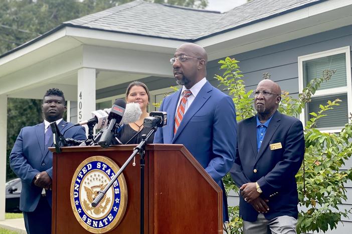 Sen. Raphael Warnock discusses newly introduced housing legislation outside of a house in Garden City.