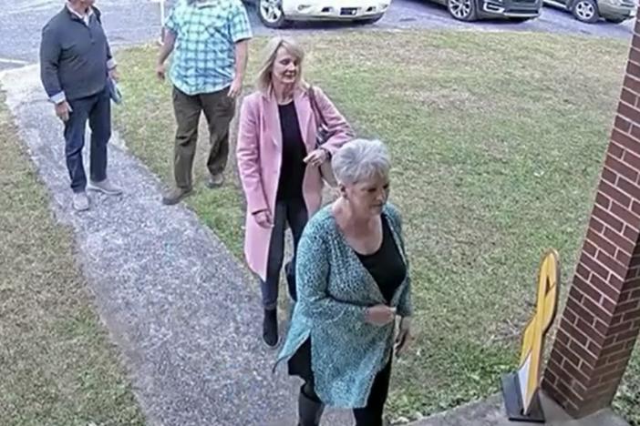  A video surveillance image taken on Jan. 19, 2021, shows former Coffee County Republican Party chair Cathy Latham, bottom right, welcoming forensic computer analysts with Atlanta-based SullivanStrickler to the county elections office. Screenshot from Coffee County video