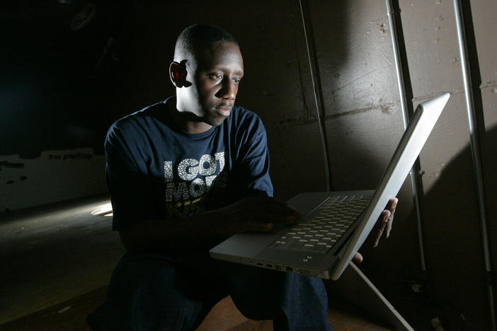 Record producer Chaka Zulu looks through material on Sept. 2, 2008, in Atlanta. Zulu, who manages rap star and actor Ludacris, faces a murder charge in Atlanta in connection with a June shooting. Police reports show that Chaka Zulu, whose legal name is Ahmed Obafemi, turned himself in to face charges Tuesday, Sept. 20, 2022.