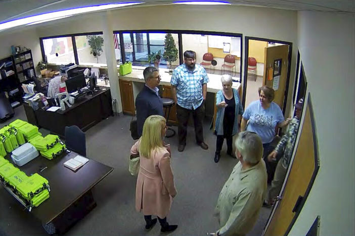 This Jan. 7, 2021, image taken from Coffee County, Ga., security video, appears to show Cathy Latham (center, long turquoise top), introducing members of a computer forensic team to local election officials. Latham was the county Republican Party chair at the time. The computer forensics team was at the county elections office in Douglas, Ga., to make copies of voting equipment in an effort that documents show was arranged by Sidney Powell and others allied with then-President Donald Trump.