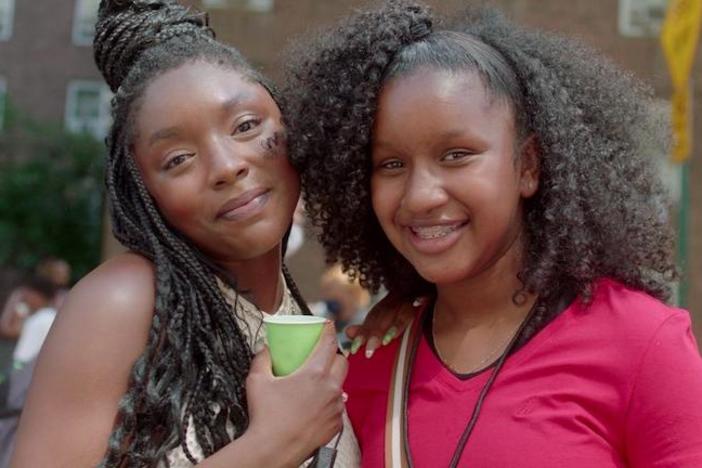 Two young woman smiling at a festival.