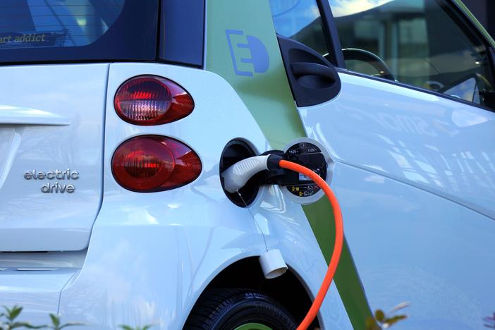 Electric vehicle plugged in at charging station.