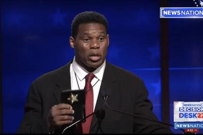 Herschel walker holds up badge.