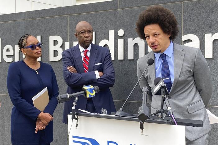 Comedian Eric André, right, speaks at a news conference outside the federal courthouse in Atlanta on Tuesday, Oct. 11, 2022, as his attorneys Allegra Lawrence-Hardy, left, and Richard Deane watch. André and comedian Clayton English filed a lawsuit Tuesday alleging that they were racially profiled and illegally stopped by Clayton County police at Hartsfield-Jackson Atlanta International Airport.