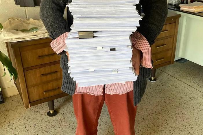 Megan Desrosiers holds the stack of petitions collected to force a referendum on the purchase of land for Spaceport Camden. Credit: One Hundred Miles