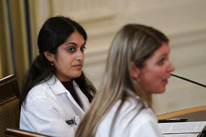 Dr. Nisha Verma, of Georgia, left, listens as Dr. Kristin Lyerly, right, from Wisconsin, speaks during a meeting of the reproductive rights task force in the State Dining Room of the White House in Washington, Tuesday, Oct. 4, 2022. President Joe Biden and Vice President Kamala Harris also attended the meeting. (AP Photo/Susan Walsh)