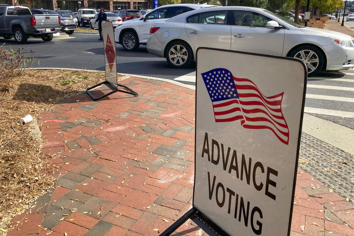 A sign showing the way for voters stands outside a Cobb County voting building during the first day of early voting, Monday, Oct. 17, 2022, in Marietta, Ga