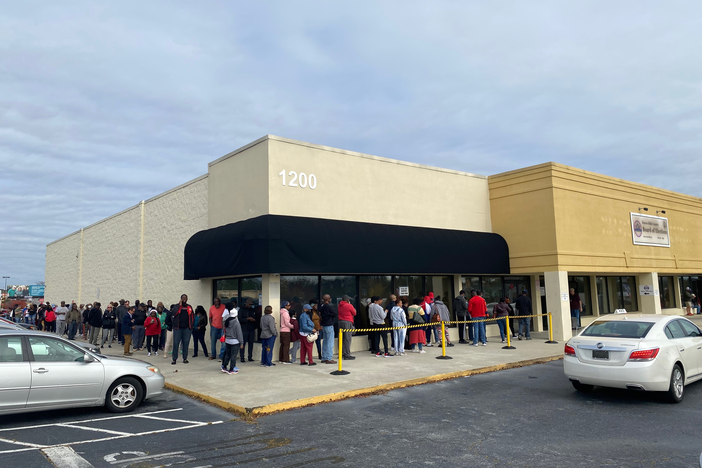 A long line of voters wait to cast ballots in Macon, Ga. on Saturday, November 26, 2022.