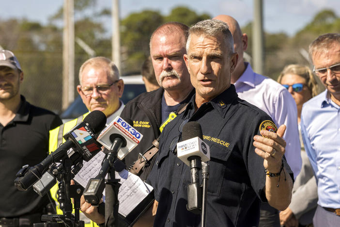 Jacksonville Fire and Rescue Department Public Information Officer Capt. Eric Prosswimmer, center, speaks at a news briefing Monday, Nov. 7, 2022, in Brunswick, Ga. A large fire burned inside a chemical plant where authorities ordered nearby neighborhoods to evacuate because of threats from toxic smoke and potential explosions.