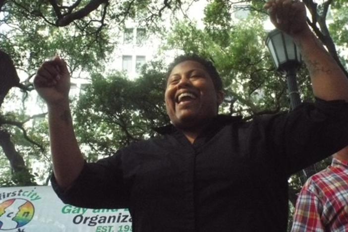 Candace Hardnett is shown raising her hands in celebration.