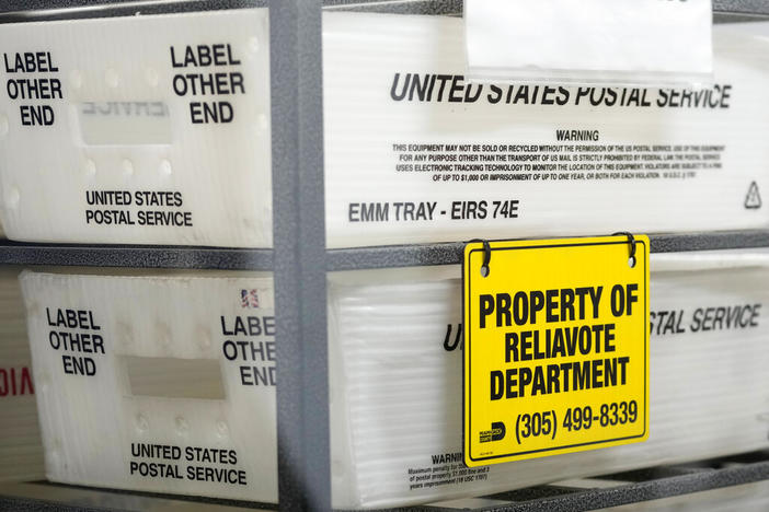 U.S. Postal Service bins are lined up to hold vote-by-mail ballots for scanning during the midterm election at the Miami-Dade County Elections Department, Nov. 8, 2022, in Miami. Republicans are re-evaluating their antipathy to mail voting. After former President Donald Trump condemned that method of casting ballots in 2020, conservatives shied away from it. That's given Democrats a multiweek jump on voting during elections. 