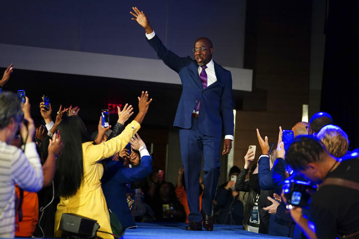 U.S. Sen. Raphael Warnock waves to supporters after defeating Republican challenger Herschel Walker in a Dec. 6, 2022, runoff election.