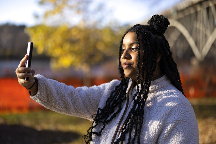 High school student Mecca Patterson-Guridy takes a self portrait in Philadelphia, Friday, Dec. 9, 2022. Scrutiny from conservatives around teaching about race, gender and sexuality has made many teachers reluctant to discuss issues that touch on cultural divides. To fill in gaps, some students, including Mecca, are looking to social media, where online personalities, nonprofit organizations and teachers are experimenting with ways to connect with them outside the confines of school.
