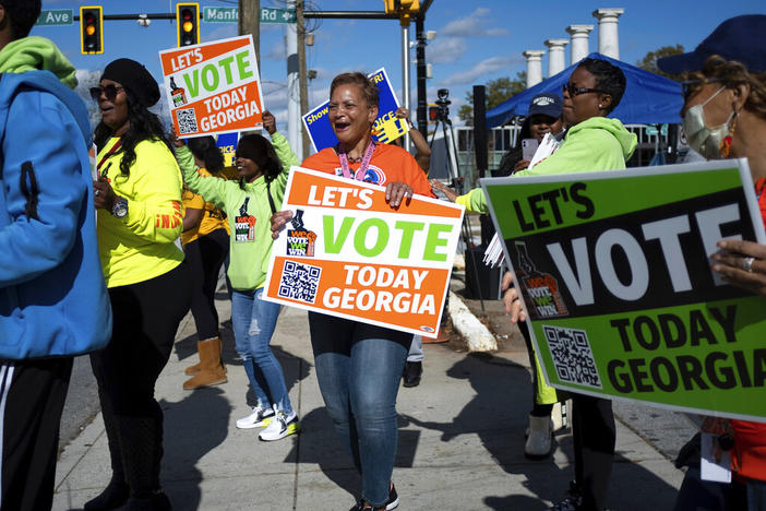 People gather during a get out the vote rally Nov. 27, 2022, in Atlanta, during early voting for the Senate runoff election. Voters in Georgia appear to have navigated the strict election law passed last year by Republicans with little difficulty. But voting rights groups say it’s too soon to assess the full impact of the law, since it’s not certain how many voters may have been dissuaded from casting a ballot.