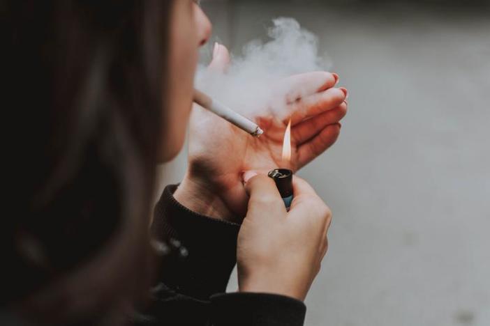 A woman lights a cigarette