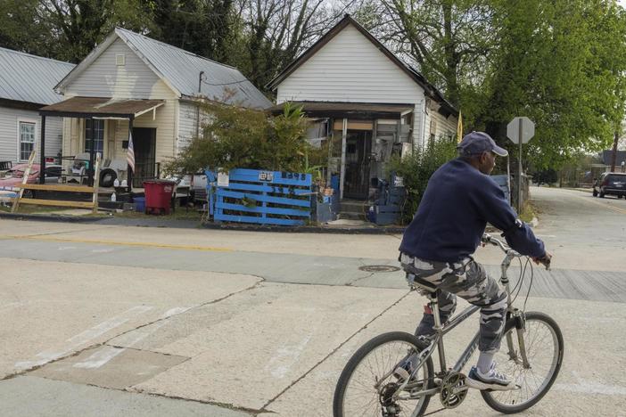 Macon resident Peter Givens rides through the Pleasant Hill neighborhood, a Black community that was split during the original construction of Interstate 75 through Macon, Ga., in the 1960s.