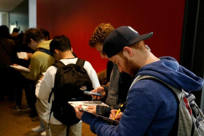A young man fills out an application to cast his ballot at the Ann Arbor clerk's satellite office on the University of Michigan campus.