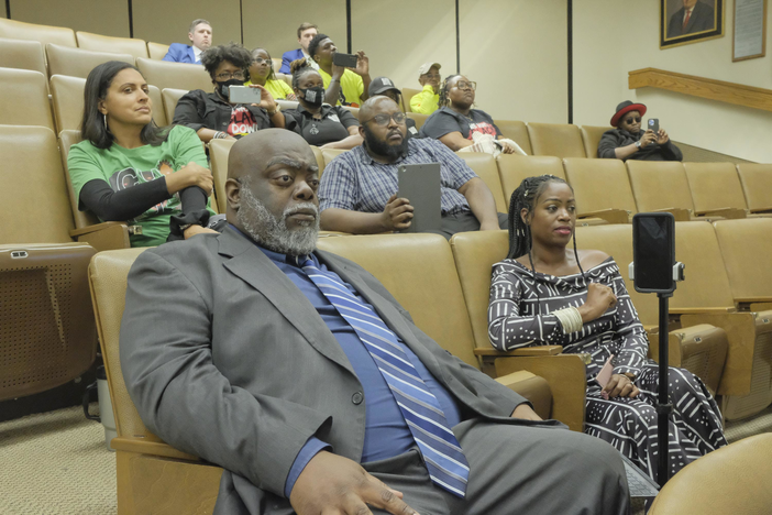 Albany City Commissioner Demetrius Young watches as the State Election Board voted to dismiss charges against him and other volunteers who passed out water and snacks at an early voting site in 2020.